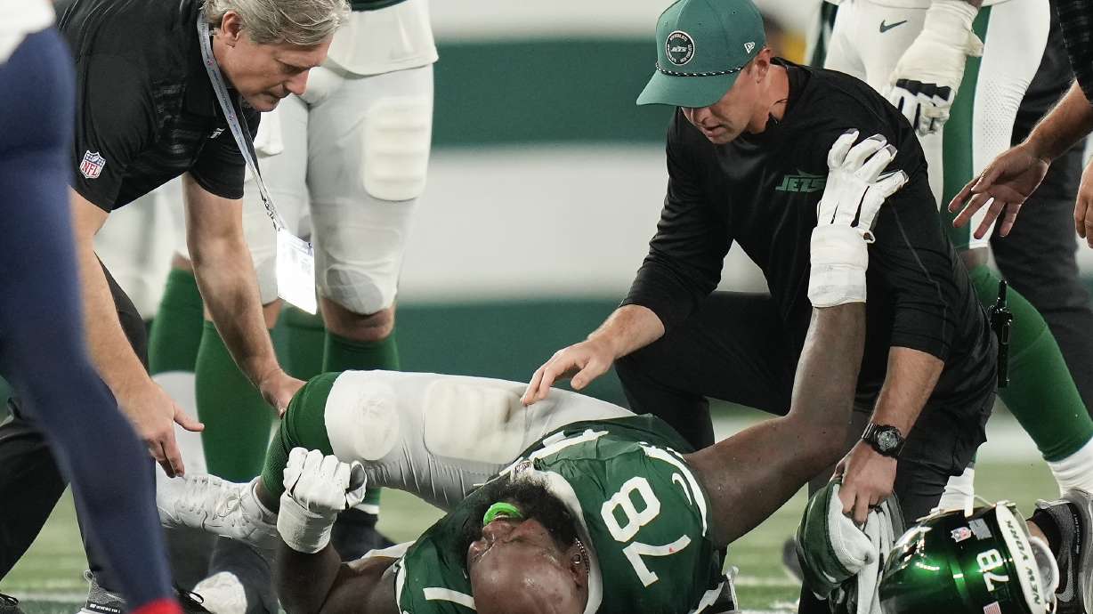 New York Jets offensive tackle Morgan Moses (78) is tended to by trainers after an injury during the third quarter of an NFL football game against the New England Patriots, Thursday, Sept. 19, 2024, in East Rutherford, N.J.