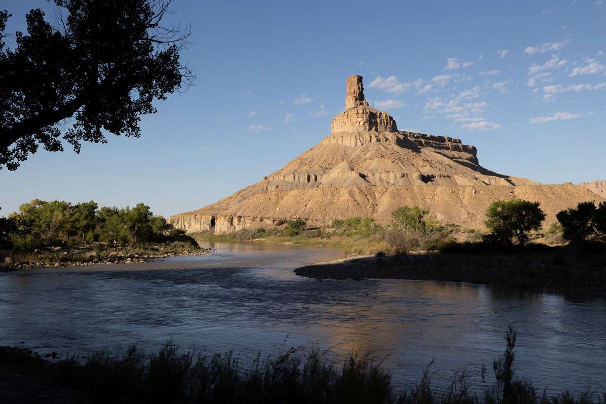 The Green River passes by a bend in this slow-moving segment of the Green River that defines the town's identity on Sept. 20. Behind, an arid mesa rises into the sky during a morning on Green River which is vital for the melon growers and other farmers in Green River