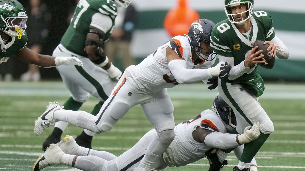 New York Jets quarterback Aaron Rodgers (8) is sacked by the Denver Broncos during the fourth quarter of an NFL football game, Sunday, Sept. 29, 2024, in East Rutherford, N.J.