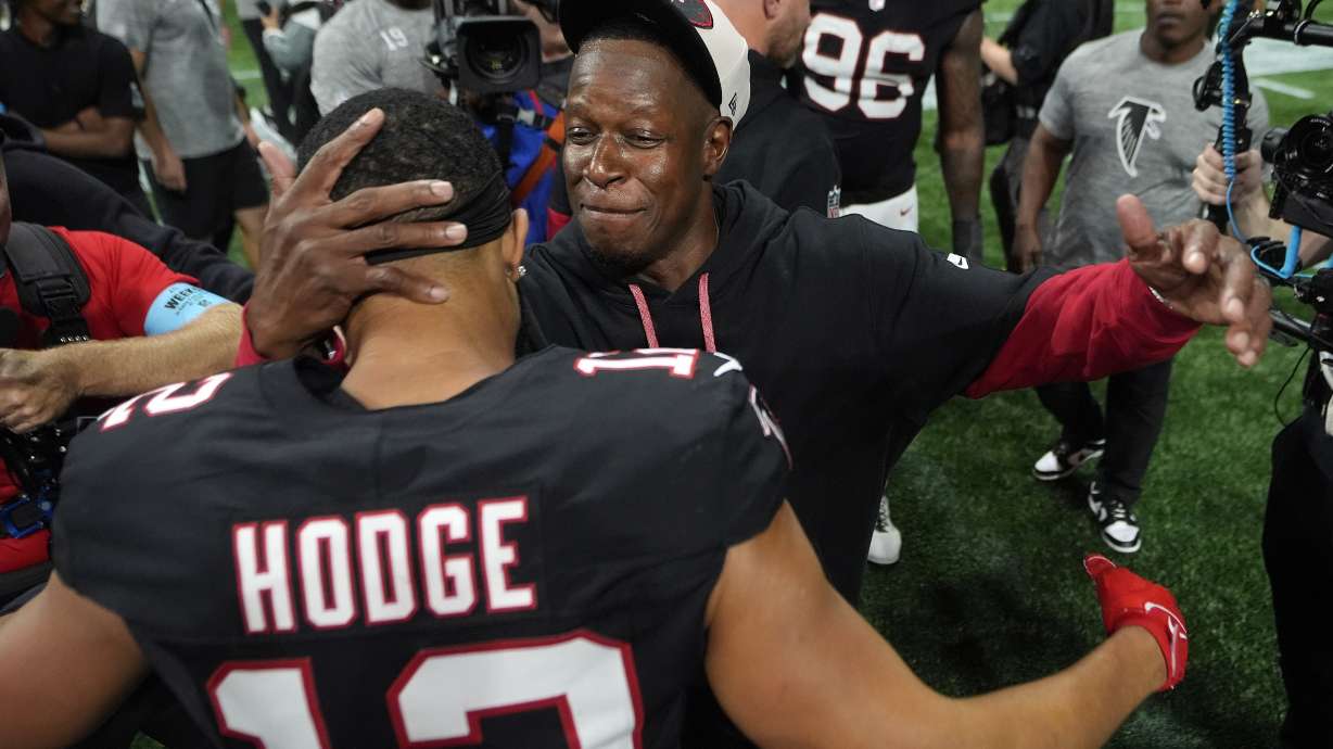 Atlanta Falcons head coach Raheem Morris celebrates with wide receiver KhaDarel Hodge (12) after scoring against the Tampa Bay Buccaneers during overtime in an NFL football game Thursday, Oct. 3, 2024, in Atlanta.
