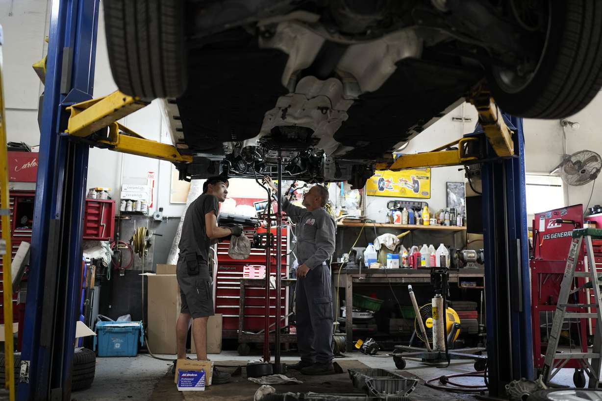 Auto mechanics work on a vehicle at the Express Auto Service Inc., in Chicago, Sept. 19.