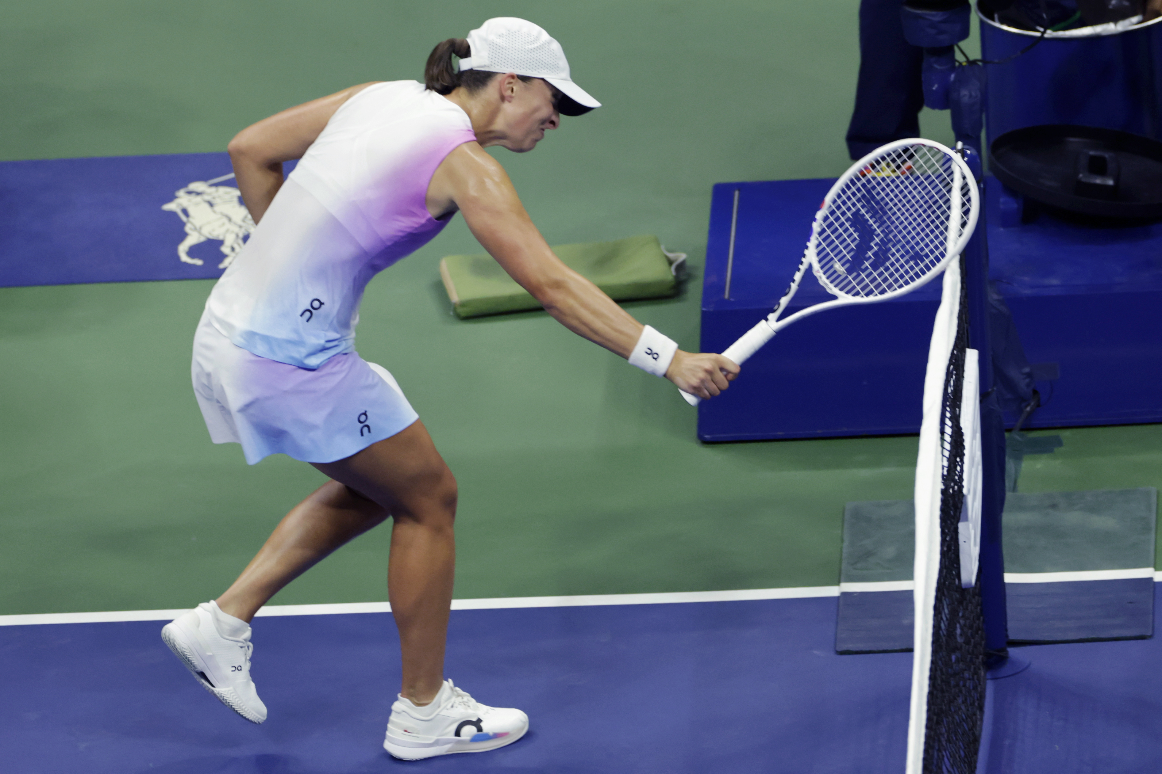 Iga Świątek, of Poland hits the net with her racquet after losing a point to Jessica Pegula, of the United States during the quarterfinals of the U.S. Open tennis championships, Wednesday, Sept. 4, 2024, in New York.