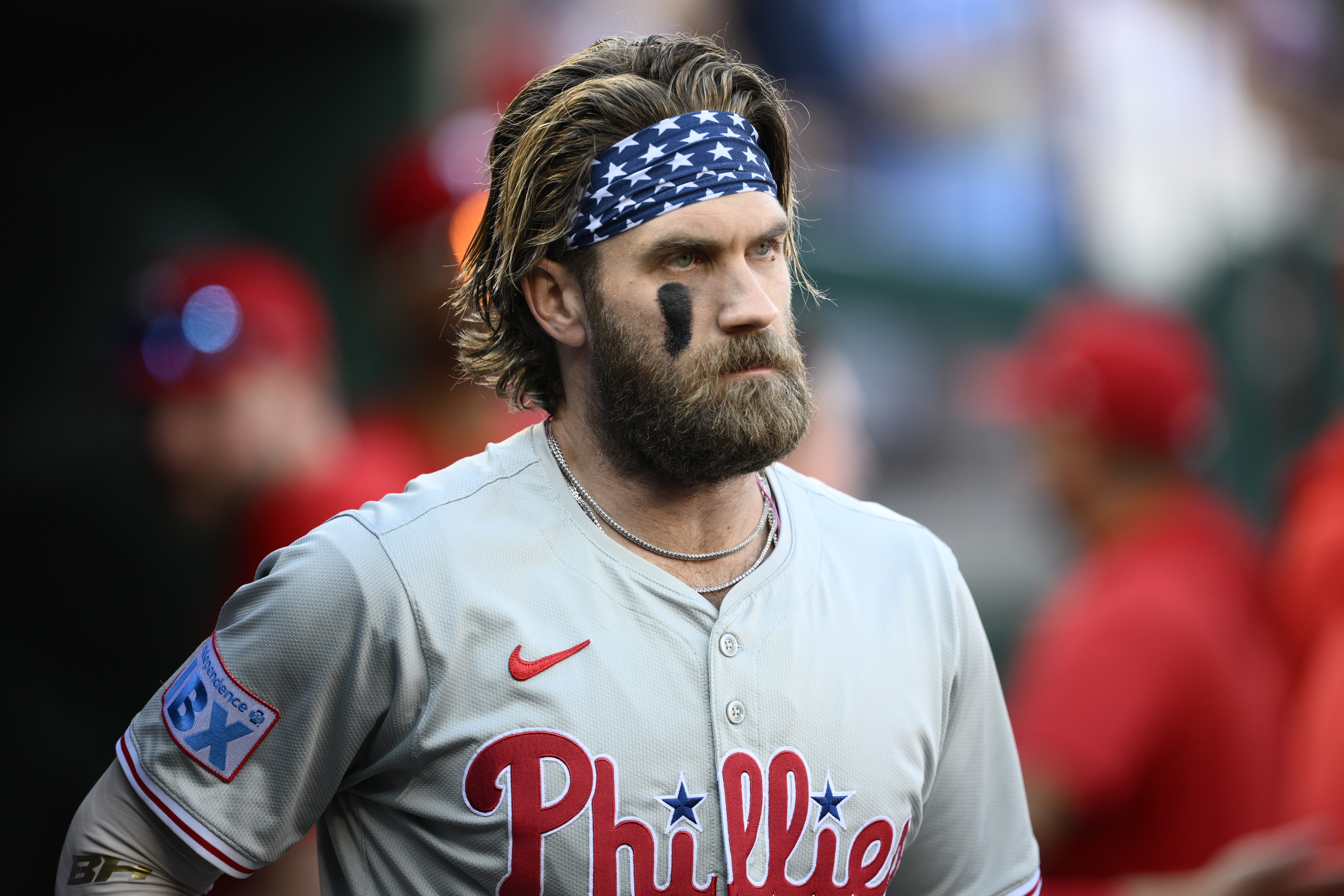 Philadelphia Phillies' Bryce Harper looks on from the dugout before a baseball game against the Washington Nationals, Saturday, Sept. 28, 2024, in Washington.