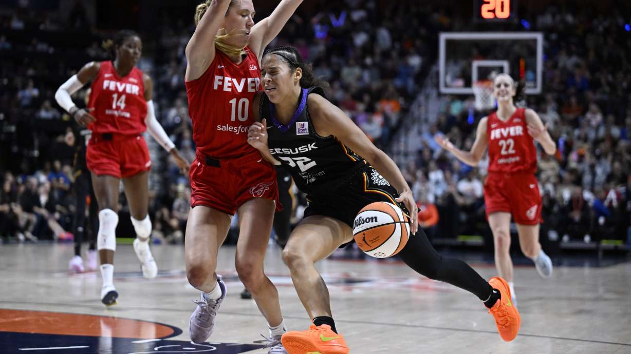 Connecticut Sun guard Veronica Burton (22) drives to the basket as Indiana Fever guard Lexie Hull (10) defends during the second half in Game 2 of a first-round WNBA basketball playoff series, Wednesday, Sept. 25, 2024, in Uncasville, Conn.