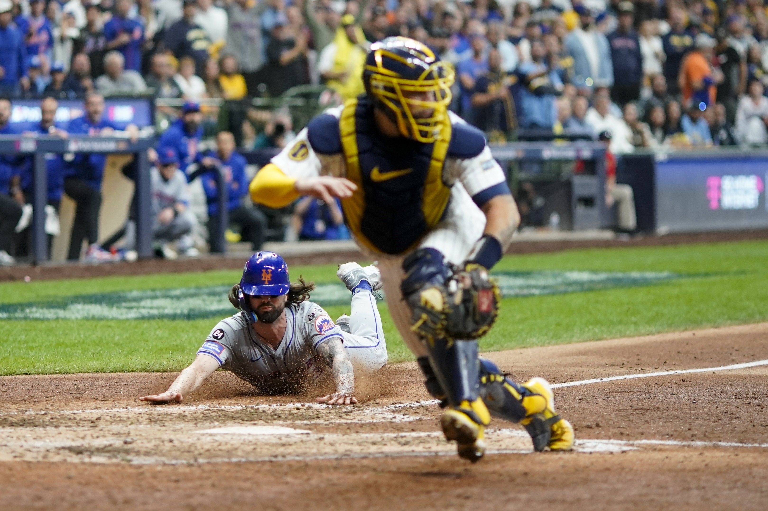 New York Mets' Jesse Winker slides safely home on a hit by Starling Marte Milwaukee Brewers catcher Gary Sánchez during the ninth inning of Game 3 of a National League wild card baseball game against the Milwaukee Brewers Thursday, Oct. 3, 2024, in Milwaukee.