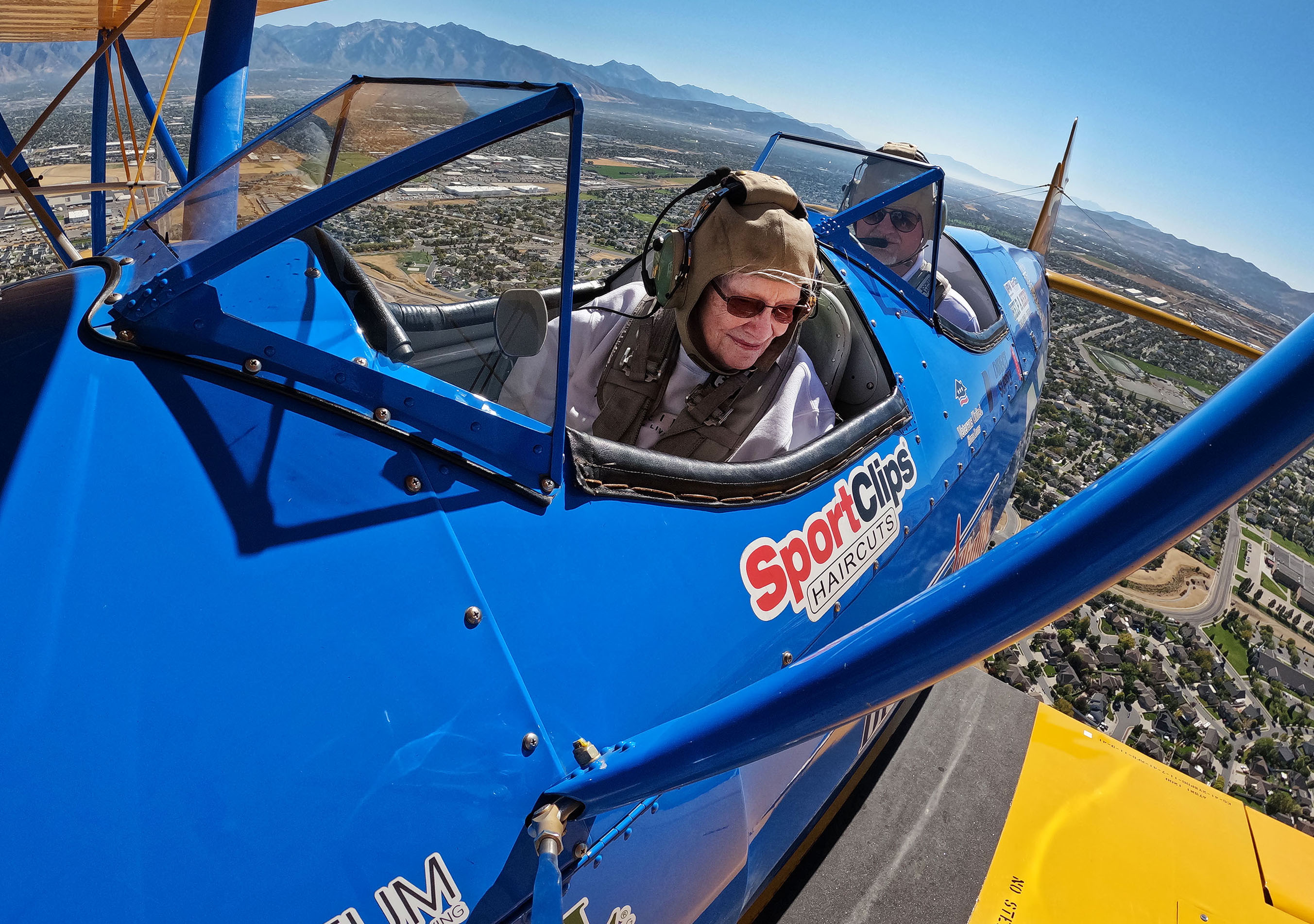 Joan Poston rides in a restored open-cockpit World War II-era biplane in West Jordan on Friday. The  flights were made for local veterans and others from The Ridge Senior Living through Dream Flights.