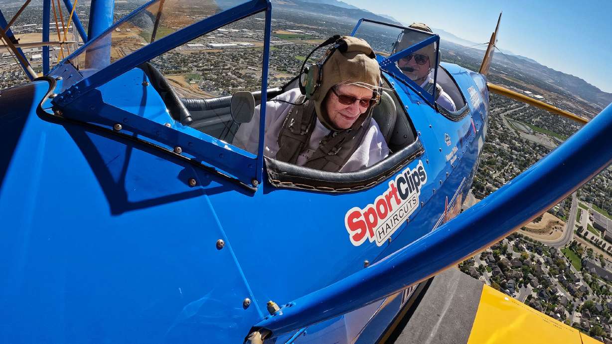 Joan Poston rides in a restored open-cockpit World War II-era biplane in West Jordan on Friday. The flights were made for local veterans and others from The Ridge Senior Living through Dream Flights.