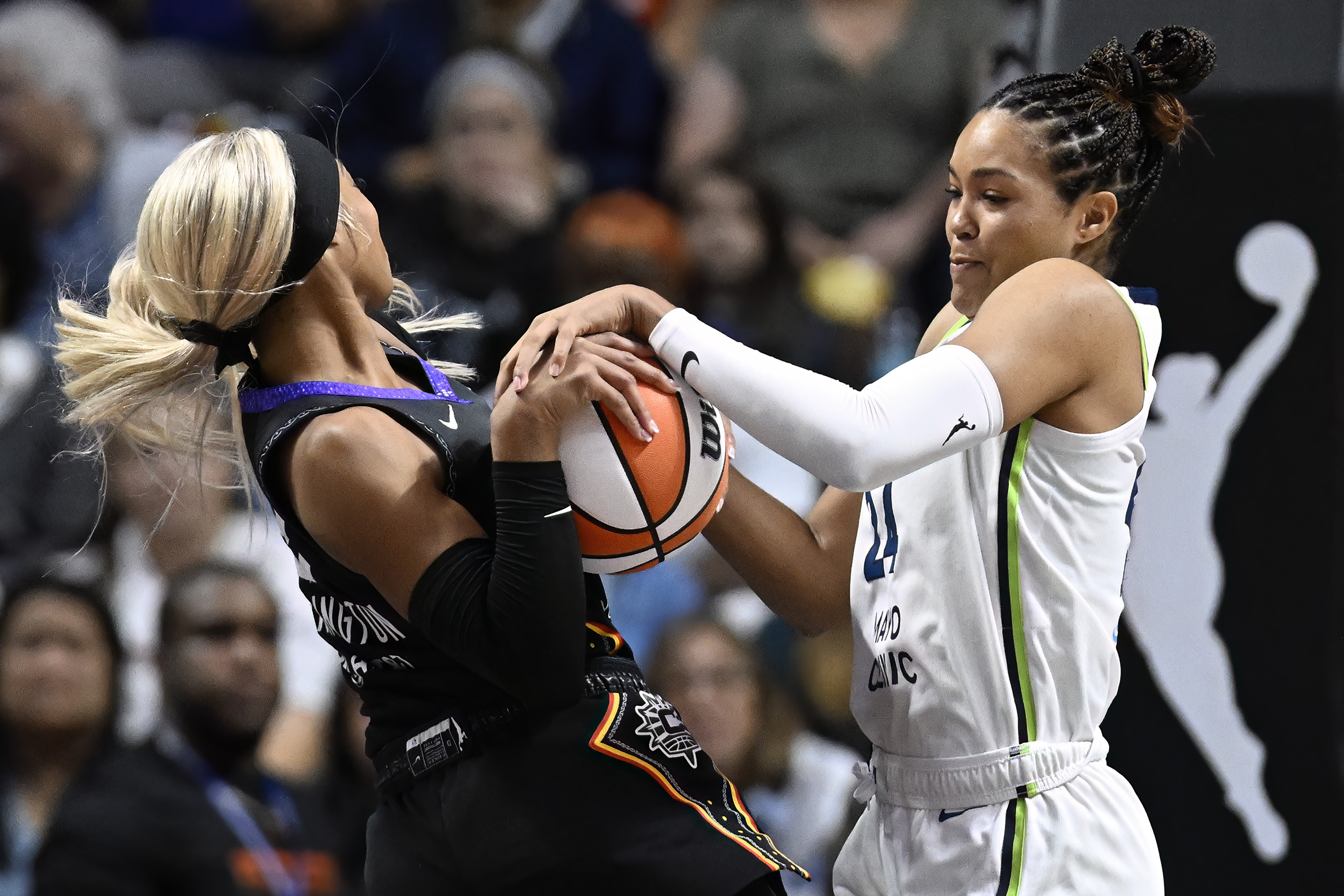 Minnesota Lynx forward Napheesa Collier pressures Connecticut Sun guard DiJonai Carrington, left, during the first half of a WNBA basketball semifinal game, Friday, Oct. 4, 2024, in Uncasville, Conn.
