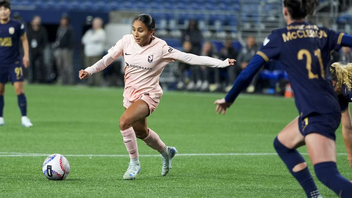 Angel City FC forward Alyssa Thompson moves the ball against Seattle Reign defender Phoebe McClernon (21) during the second half of an NWSL soccer match Friday, Oct. 4, 2024, in Seattle. Angel City won 1-0.