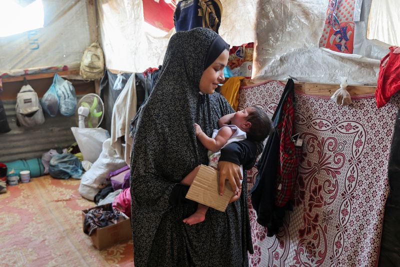 Displaced Palestinian mother Rana Salah holds her daughter Milana in a tent where they shelter, amid the Israel-Hamas conflict, in Deir Al-Balah in the central Gaza Strip, Sept. 10.