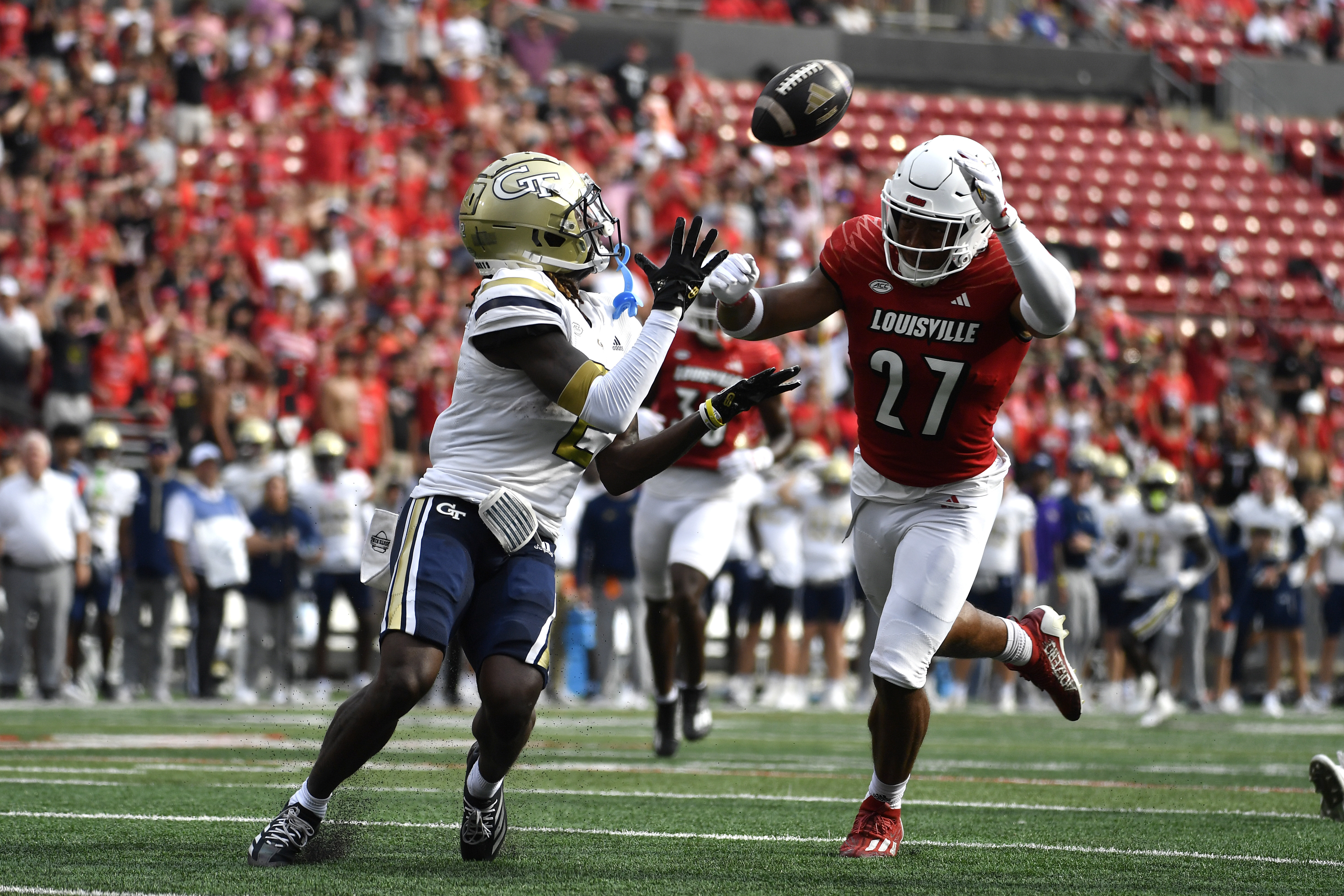 Georgia Tech wide receiver Eric Singleton Jr. (2) attempts to make a catch away from the pressure of Louisville defensive back Devin Neal (27) during the first half of an NCAA college football game in Louisville, Ky., Saturday, Sept. 21, 2024.