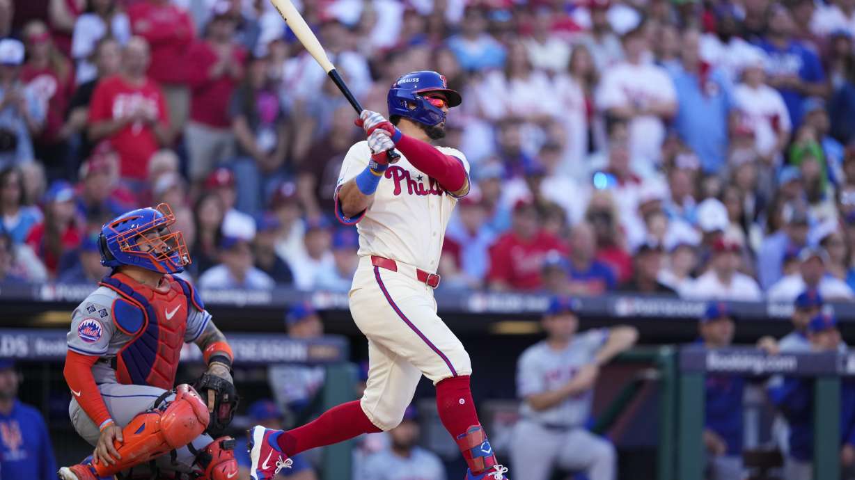 Philadelphia Phillies' Kyle Schwarber follows through after hitting a home run off of New York Mets pitcher Kodai Senga during the first inning of Game 1 of a baseball NL Division Series, Saturday, Oct. 5, 2024, in Philadelphia.