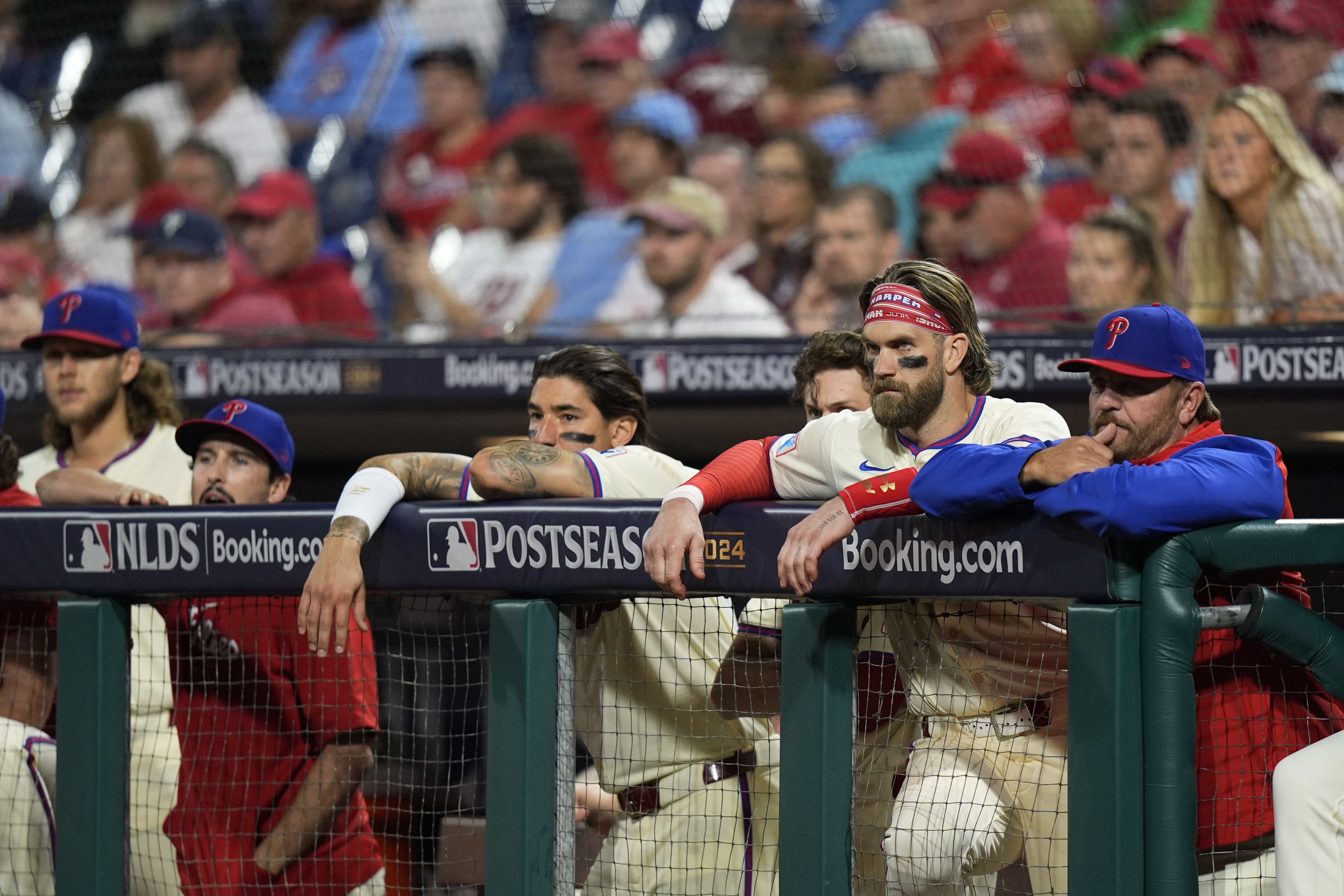 Philadelphia Phillies' Bryce Harper, second right, looks on from the dugout with teammates during the ninth inning of Game 1 of a baseball NL Division Series against the New York Mets, Saturday, Oct. 5, 2024, in Philadelphia.