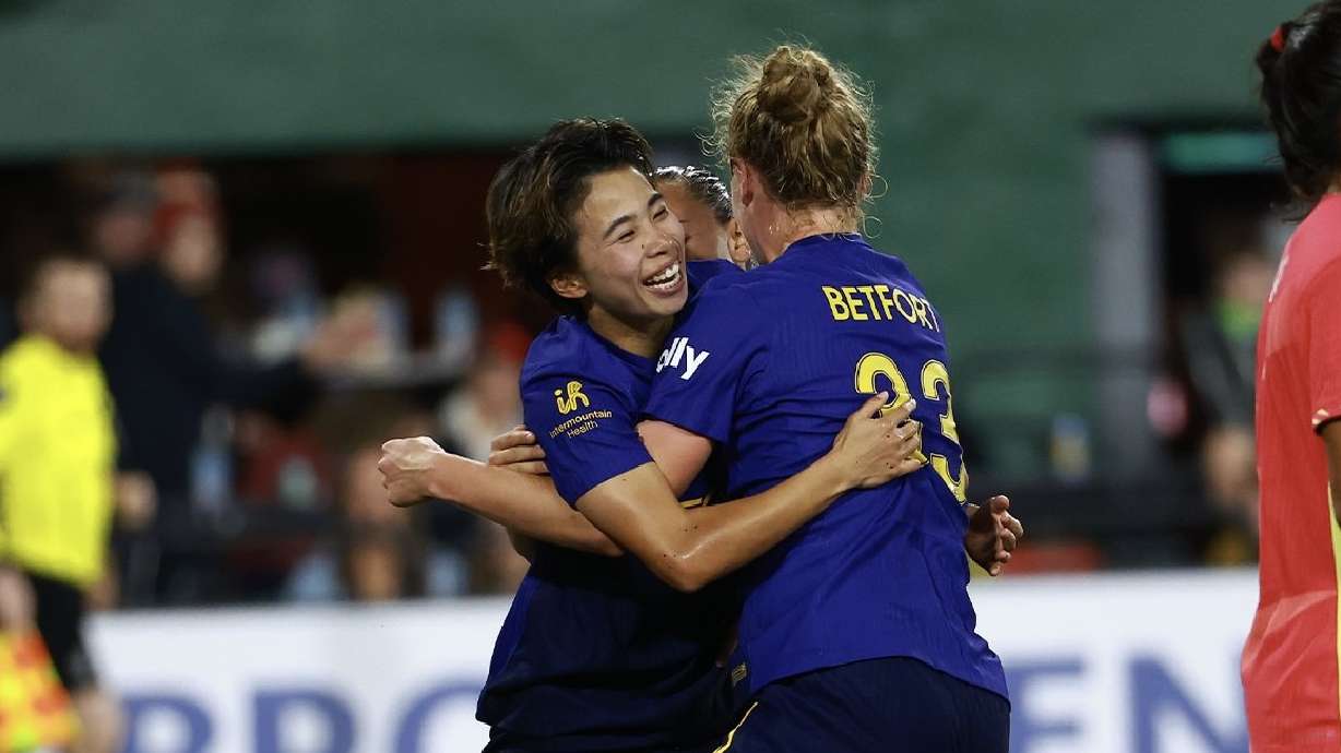 Mina Tanaka, left, and Hannah Betfort, right, celebrate a goal in Portland.