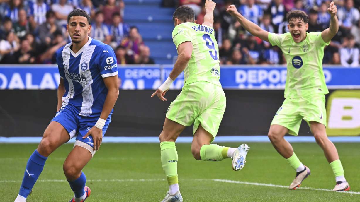 Barcelona's Robert Lewandowski, center, celebrates after scoring the opening goal against Alaves during a Spanish La Liga soccer match at the Mendizorroza stadium in Vitoria-Gasteiz, Spain, Sunday, Oct. 6, 2024.