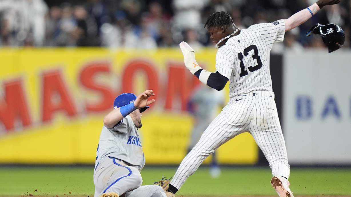 New York Yankees' Jazz Chisholm Jr. (13) slides safely into second base ahead of the tag from Kansas City Royals second baseman Michael Massey during the seventh inning of Game 1 of the American League baseball division series, Saturday, Oct. 5, 2024, in New York.