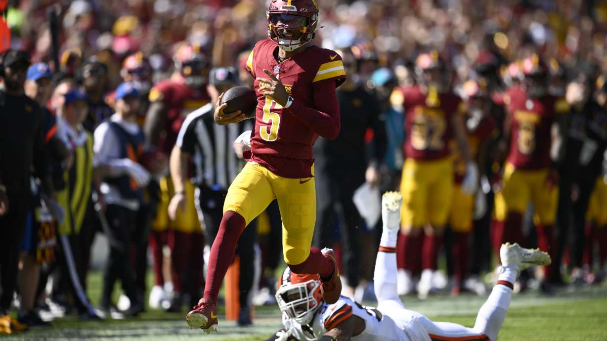 Washington Commanders quarterback Jayden Daniels (5) runs past Cleveland Browns defensive end Ogbo Okoronkwo (54) during the first half of an NFL football game in Landover, Md., Sunday, Oct. 6, 2024.