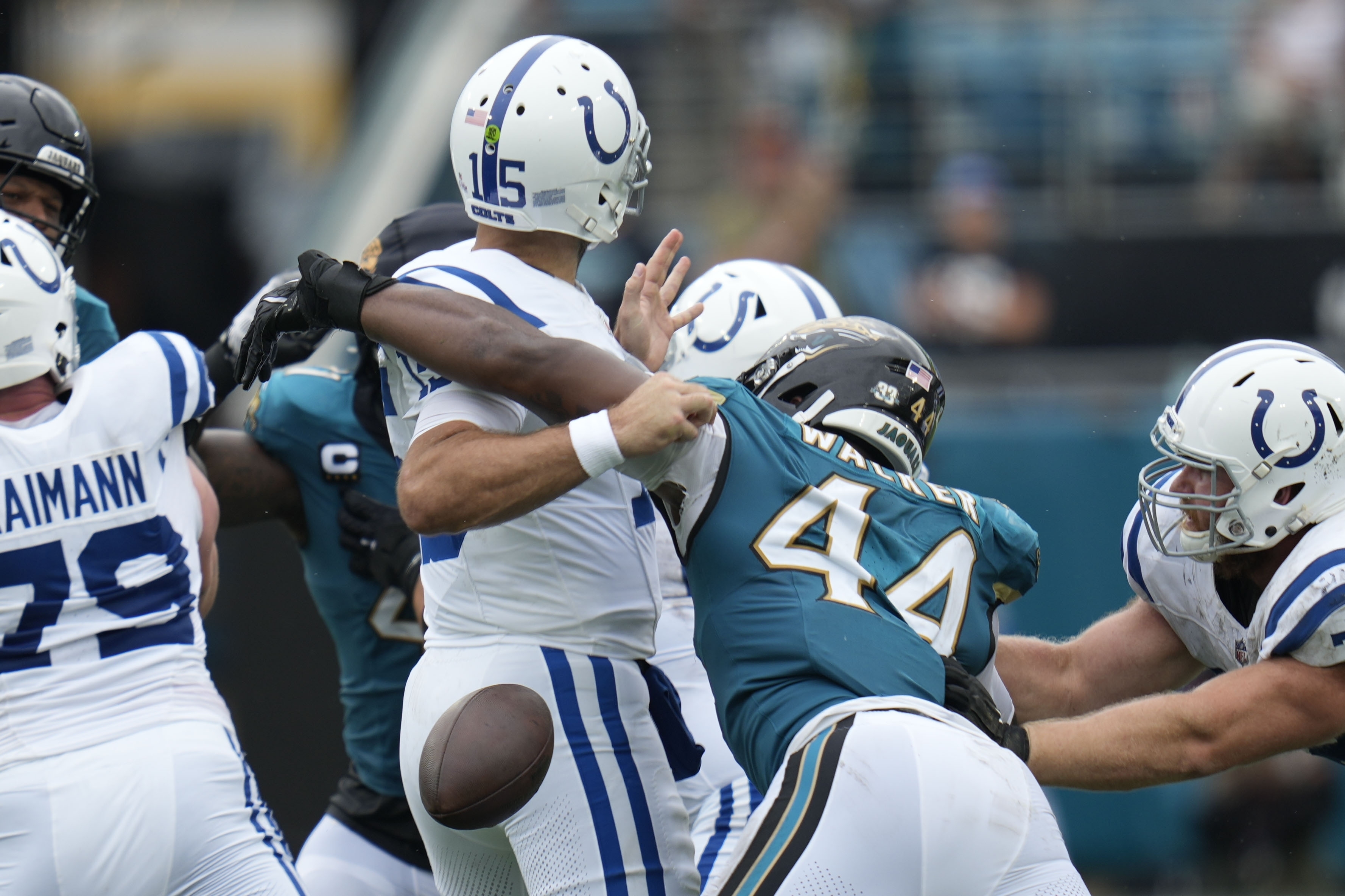 Indianapolis Colts quarterback Joe Flacco (15) fumbles as he is hit by Jacksonville Jaguars' Travon Walker (44) during the first half of an NFL football game, Sunday, Oct. 6, 2024, in Jacksonville, Fla. 