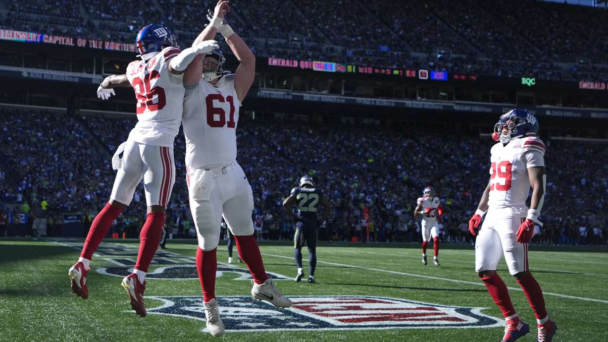 New York Giants wide receiver Darius Slayton (86), left, celebrates with teammates after scoring a 30-yard touchdown during the second half of an NFL football game against the Seattle Seahawks, Sunday, Oct. 6, 2024, in Seattle.