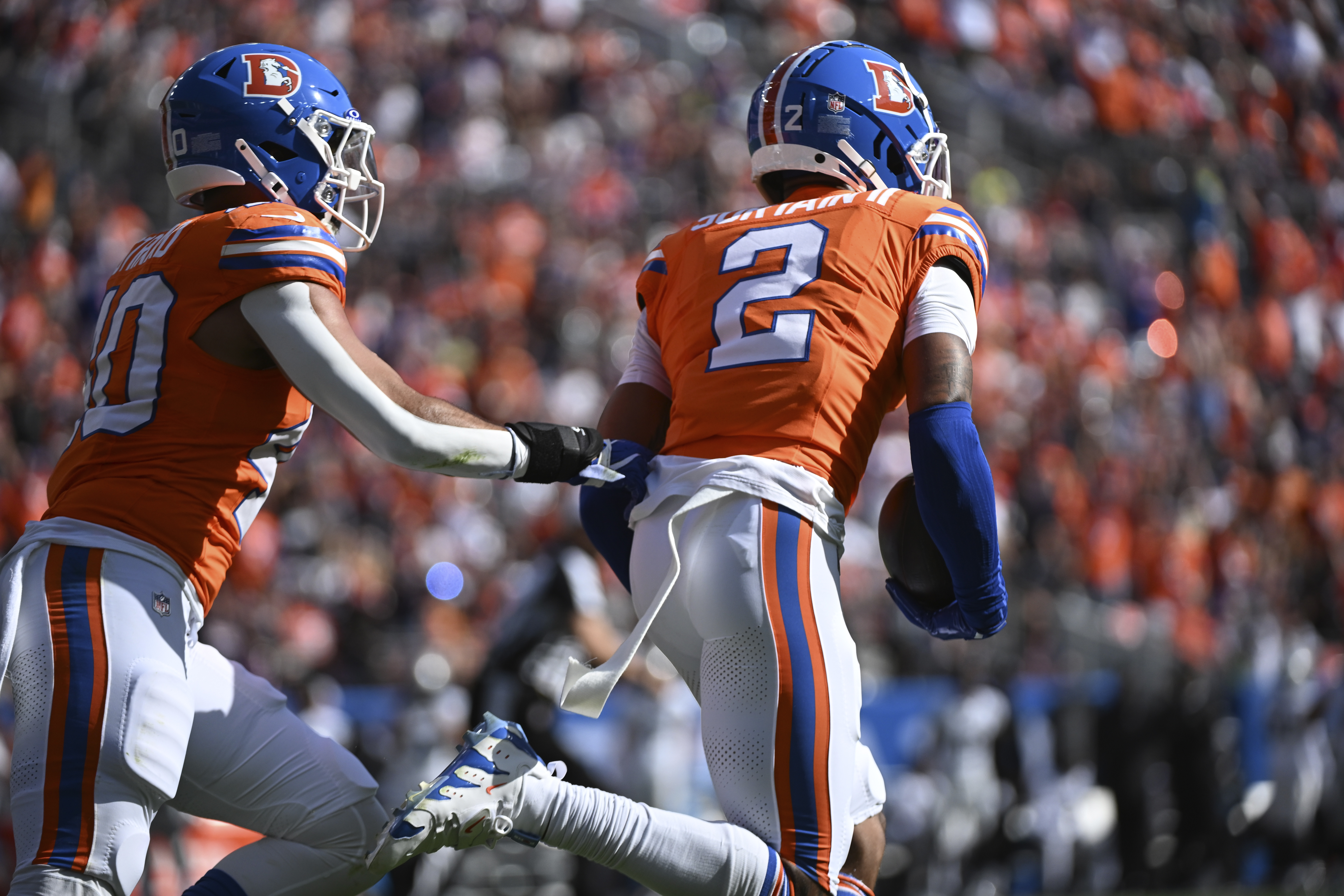 Denver Broncos cornerback Pat Surtain II (2) intercepts a pass and returns it for a 100-yard touchdown during the first half of an NFL football game against the Las Vegas Raiders, Sunday, Oct. 6, 2024, in Denver.