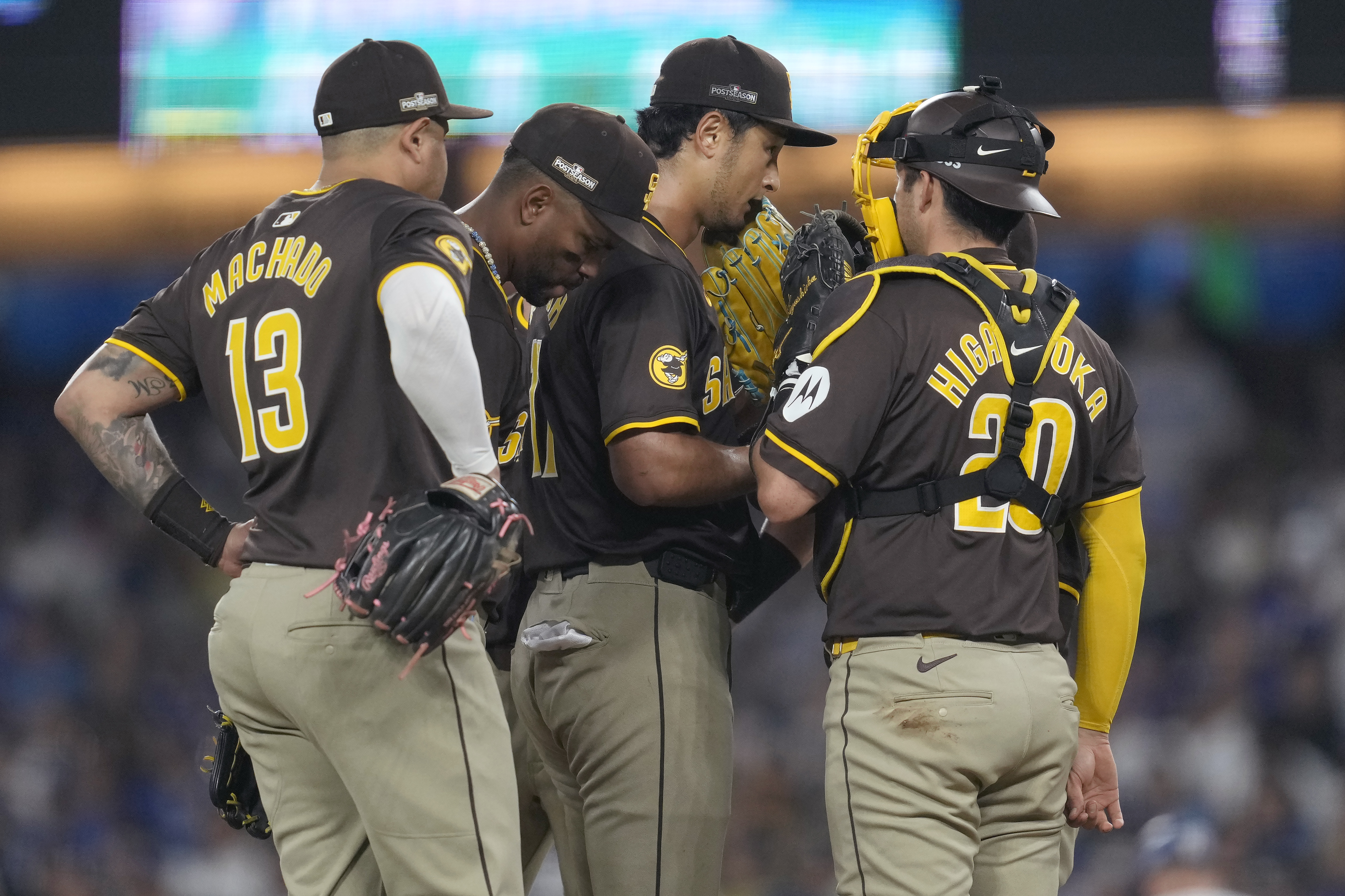 San Diego Padres pitcher Yu Darvish, middle right, talks with third baseman Manny Machado (13), shortstop Xander Bogaerts, middle left, and catcher Kyle Higashioka on the mound during the sixth inning in Game 2 of a baseball NL Division Series against the Los Angeles Dodgers, Sunday, Oct. 6, 2024, in Los Angeles.