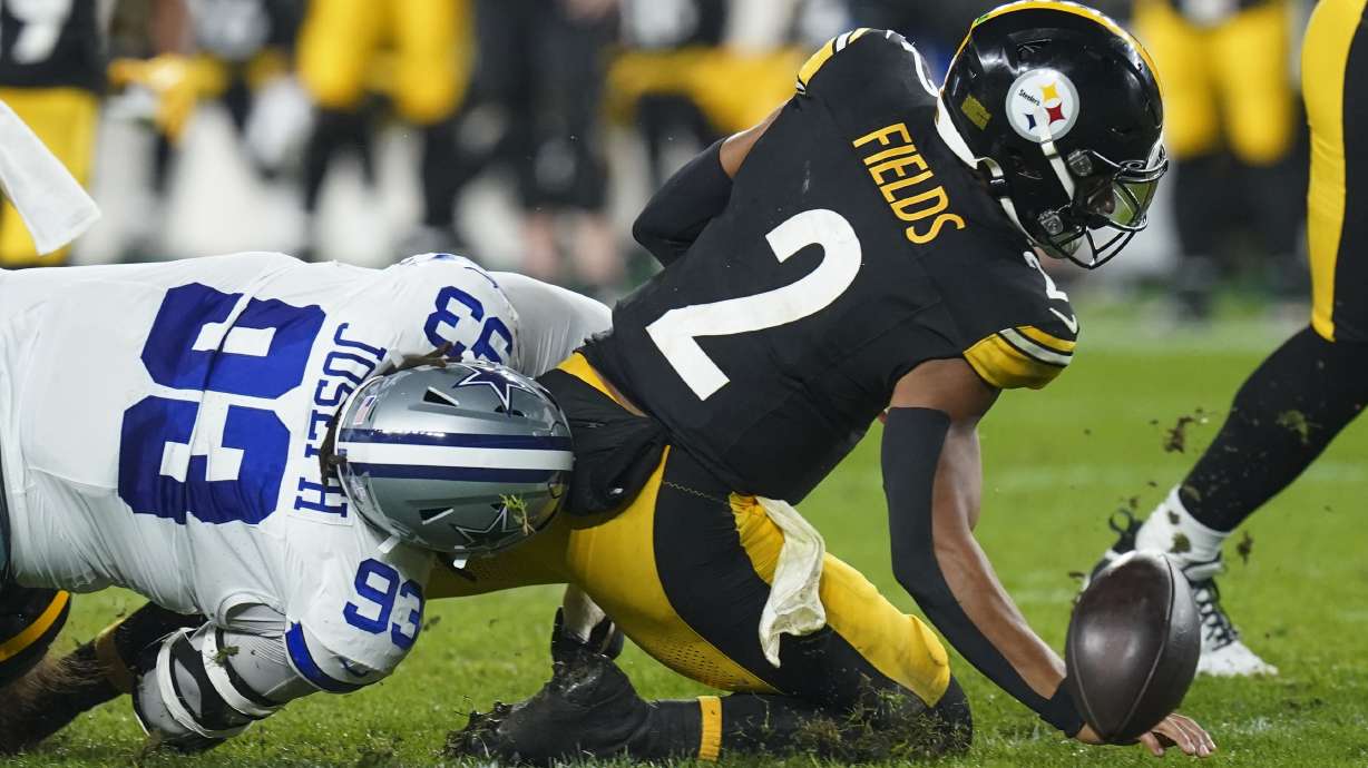 Pittsburgh Steelers quarterback Justin Fields (2) fumbles the ball while being hit by Dallas Cowboys defensive tackle Linval Joseph (93) during the first half of an NFL football game, Sunday, Oct. 6, 2024, in Pittsburgh. Fields recovered the fumble.