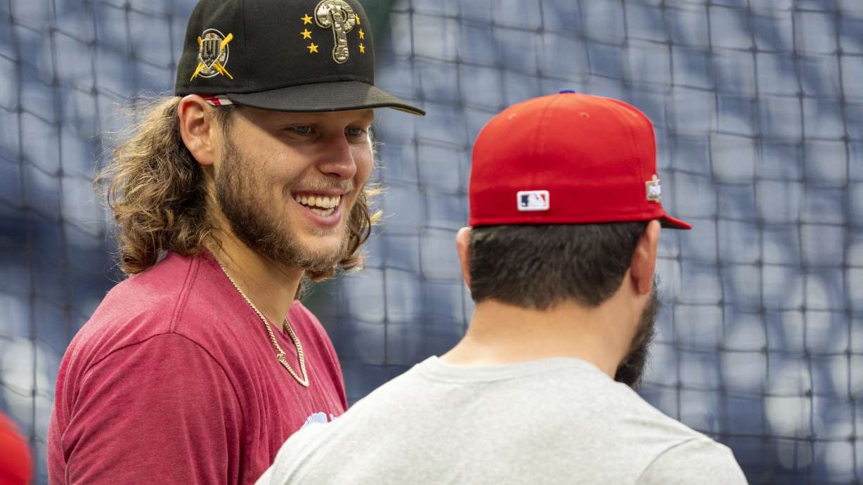 Philadelphia Phillies' Alec Bohm, left, talks with Kyle Schwarber, right, during a baseball workout, Friday, Oct. 4, 2024, in Philadelphia, ahead of the National League Division Series against the New York Mets.