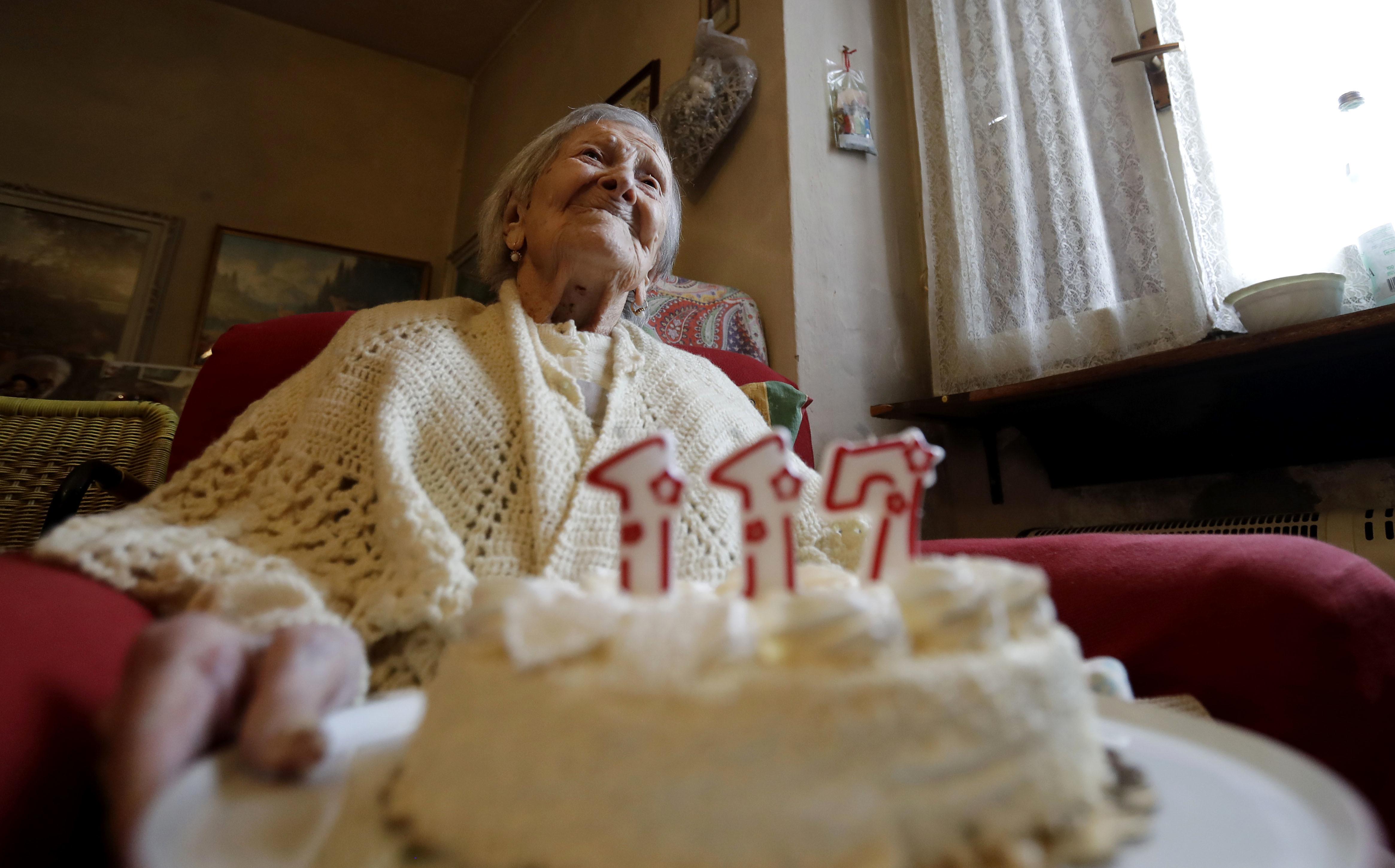 Emma Morano holds a cake with candles marking 117 years on the day of her birthday, Nov. 29, 2016, in Verbania, Italy. A new study suggests that humanity is hitting the upper limit of life expectancy. 