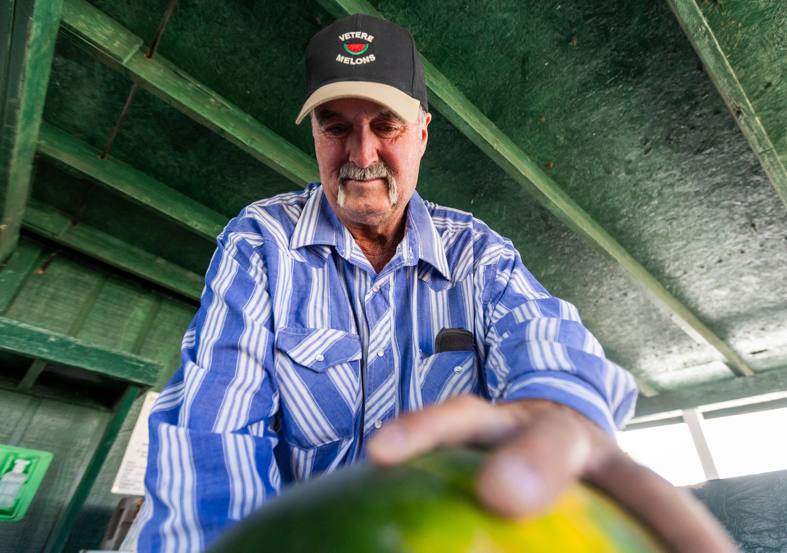 Greg Vetere slices into a watermelon to give out samples to customers at his families melon stand in Green River on Sept. 19. Vetere is a third-generation melon farmer continuing the farming tradition started by his grandfather.