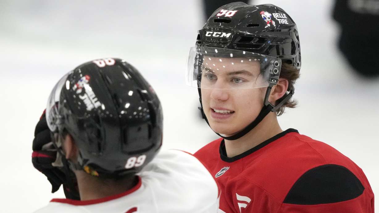 Chicago Blackhawks' Connor Bedard talks with Andreas Athanasiou during the team's NHL hockey training camp Thursday, Sept. 19, 2024, in Chicago.