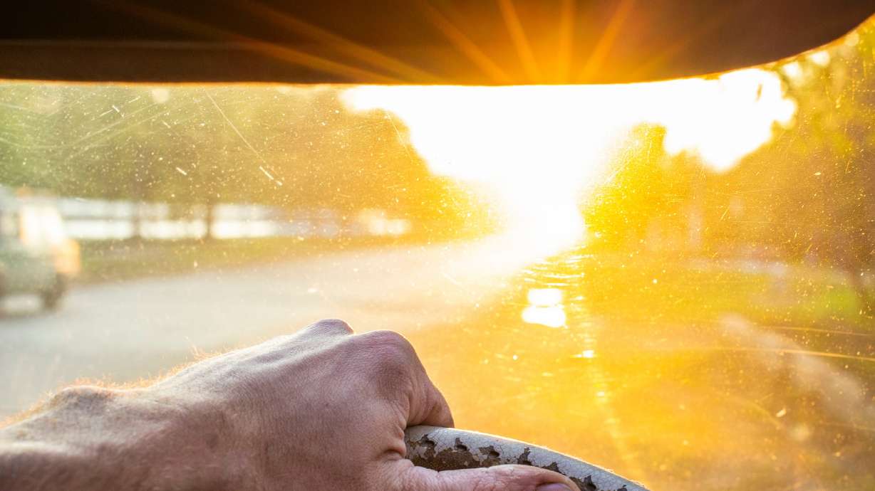 Police say a driver who was having a hard time seeing Monday morning because of the bright sun knocked down a school crossing guard in Mapleton.