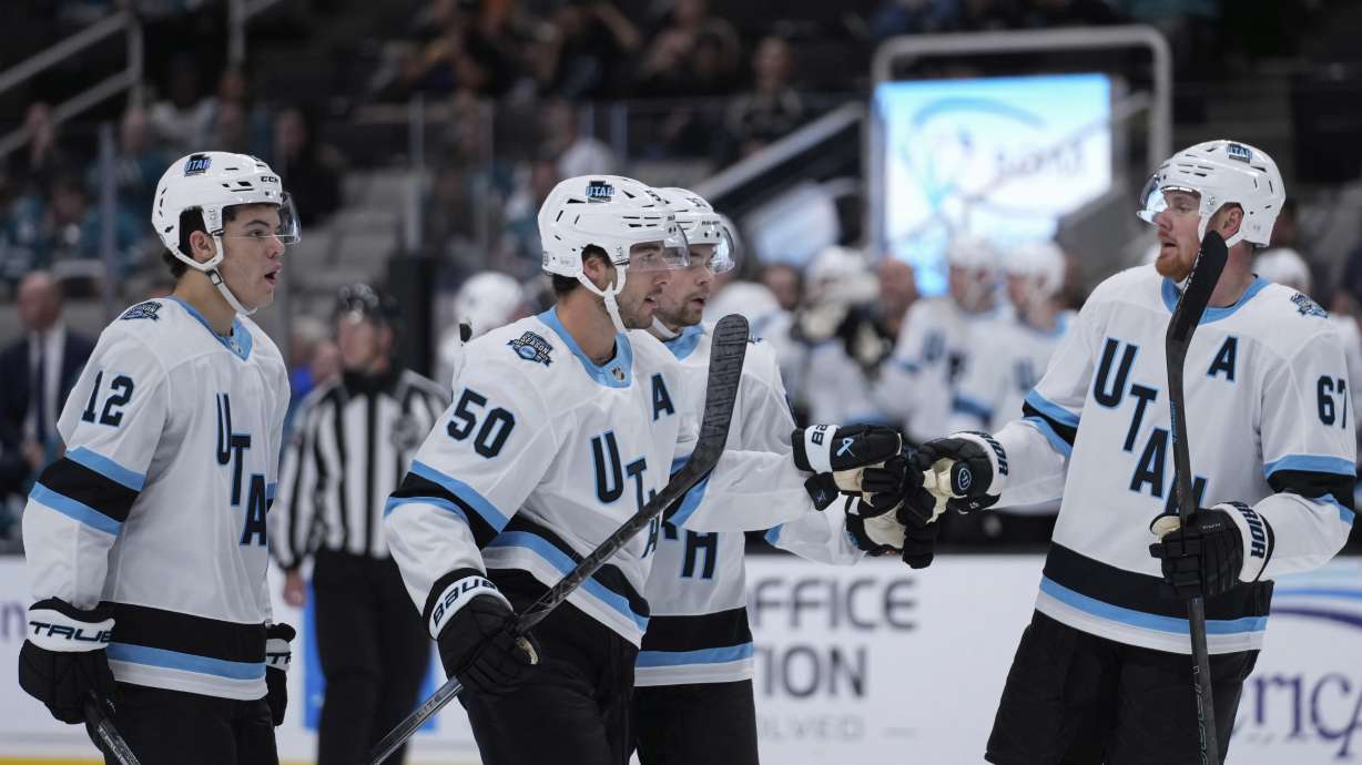 Utah defenseman Sean Durzi (50) celebrates with Lawson Crouse, right, after scoring a goal during the second period of a preseason NHL hockey game against the San Jose Sharks, Tuesday, Oct. 1, 2024, in San Jose, Calif.