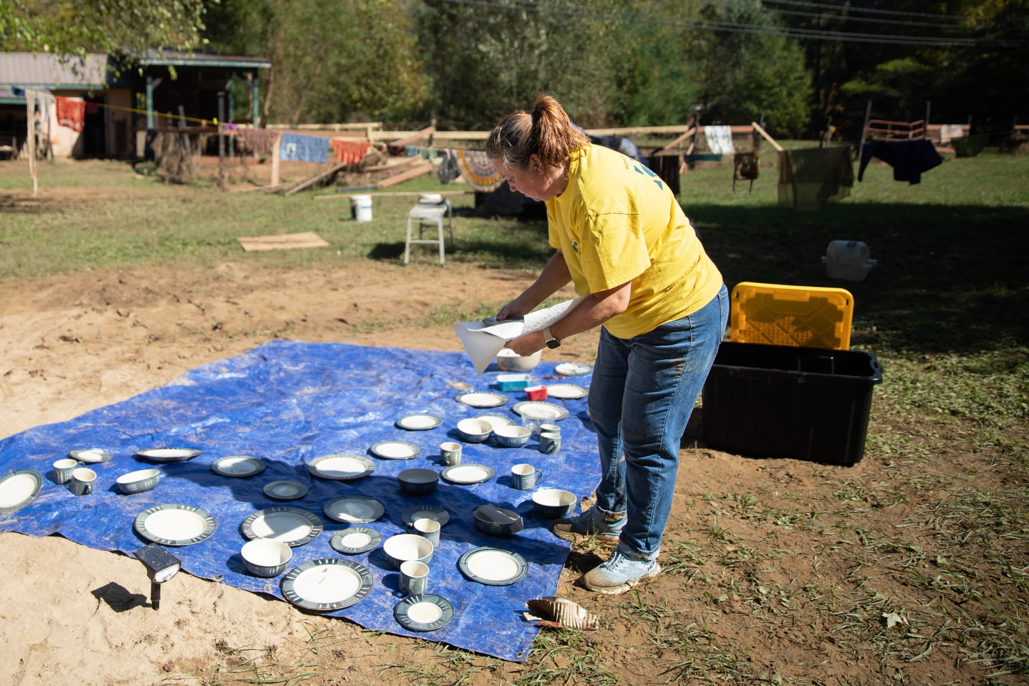 Stacey Bruno, a volunteer of The Church of Jesus Christ of Latter-day Saints from Columbia, South Carolina, sets out dishware to dry at Carolyn Ward’s home in Fairview, North Carolina, on Saturday.