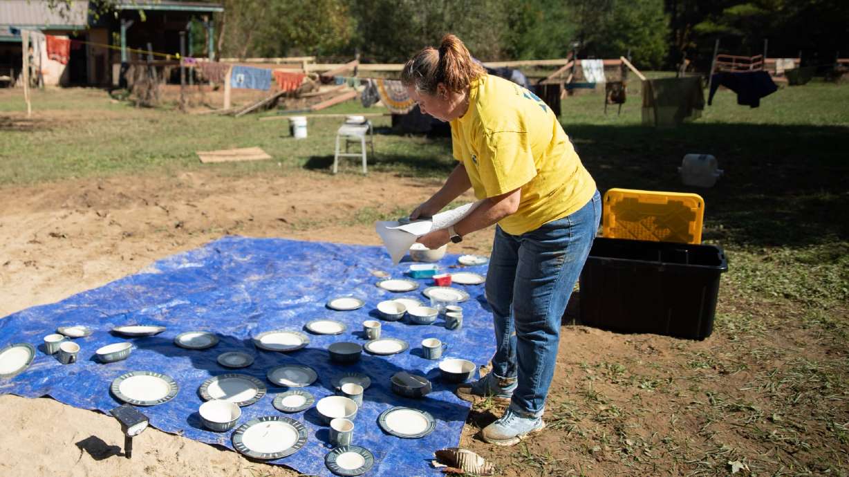 Stacey Bruno, a volunteer of The Church of Jesus Christ of Latter-day Saints from Columbia, South Carolina, sets out dishware to dry at Carolyn Ward’s home in Fairview, North Carolina, on Saturday.