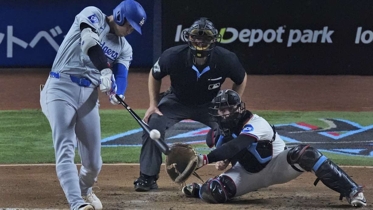 Los Angeles Dodgers' Shohei Ohtani, of Japan, hits a home run scoring Hunter Feduccia during the third inning of a baseball game against the Miami Marlins, Tuesday, Sept. 17, 2024, in Miami.