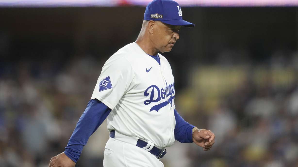 Los Angeles Dodgers manager Dave Roberts walks back to the dugout after making a pitching change during the seventh inning in Game 2 of a baseball NL Division Series against the San Diego Padres, Sunday, Oct. 6, 2024, in Los Angeles.