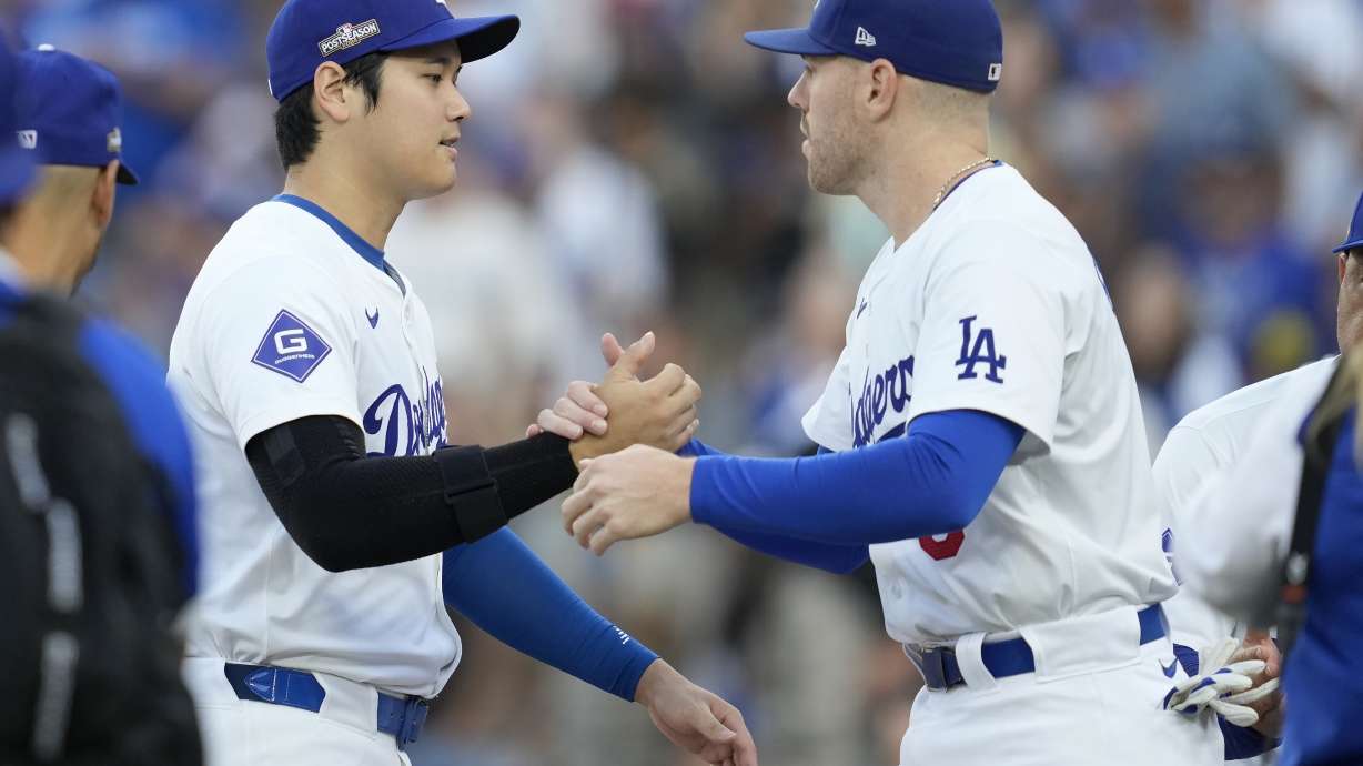 Los Angeles Dodgers' Shohei Ohtani, left, shakes hands with Freddie Freeman before Game 1 of baseball's NL Division Series against the San Diego Padres, Saturday, Oct. 5, 2024, in Los Angeles.