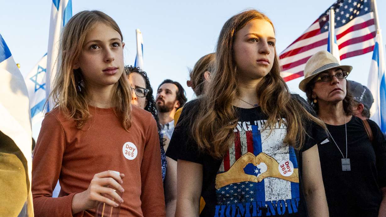Cousins Noa Keren, right, and Yally Keren hold hands during a prayer at a memorial to mark the one-year anniversary of the Oct. 7, 2023, attack on Israel by Hamas, at the state Capitol in Salt Lake City on Monday.