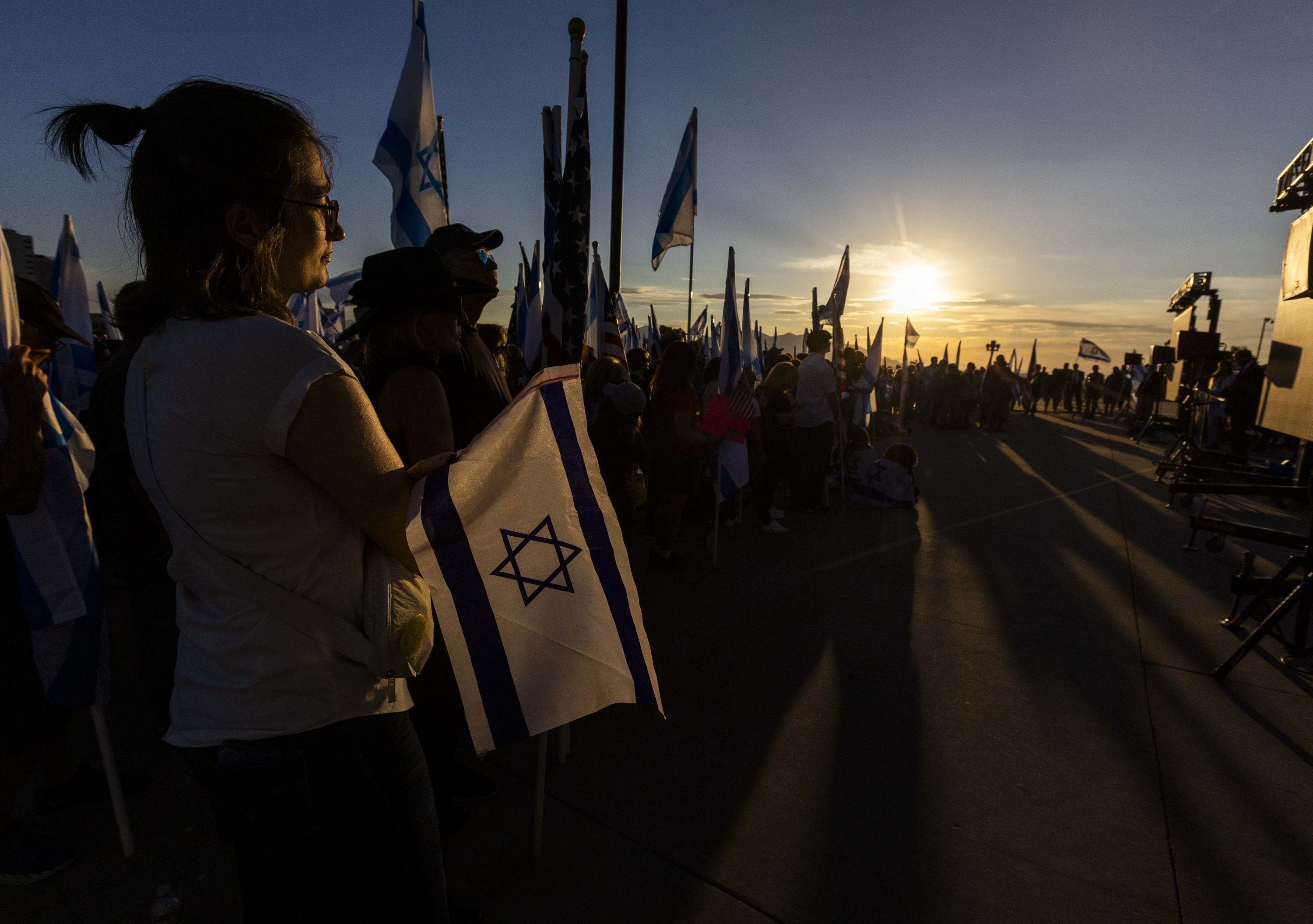 Elle Lyne-Schiffer, of the Sugar House neighborhood, left, holds an Israeli flag while listening to a prayer with others at a memorial to commemorate the one-year anniversary of the Oct. 7, 2023, attack on Israel by Hamas, at the state Capitol in Salt Lake City on Monday.