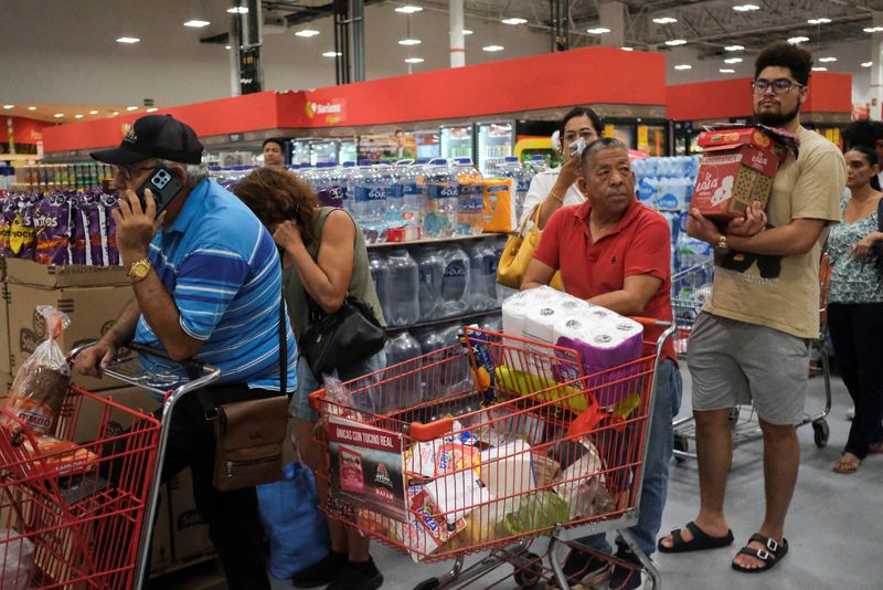 People line up to pay for food and supplies in a supermarket as Hurricane Milton advances, in Cancun, Mexico, Monday.