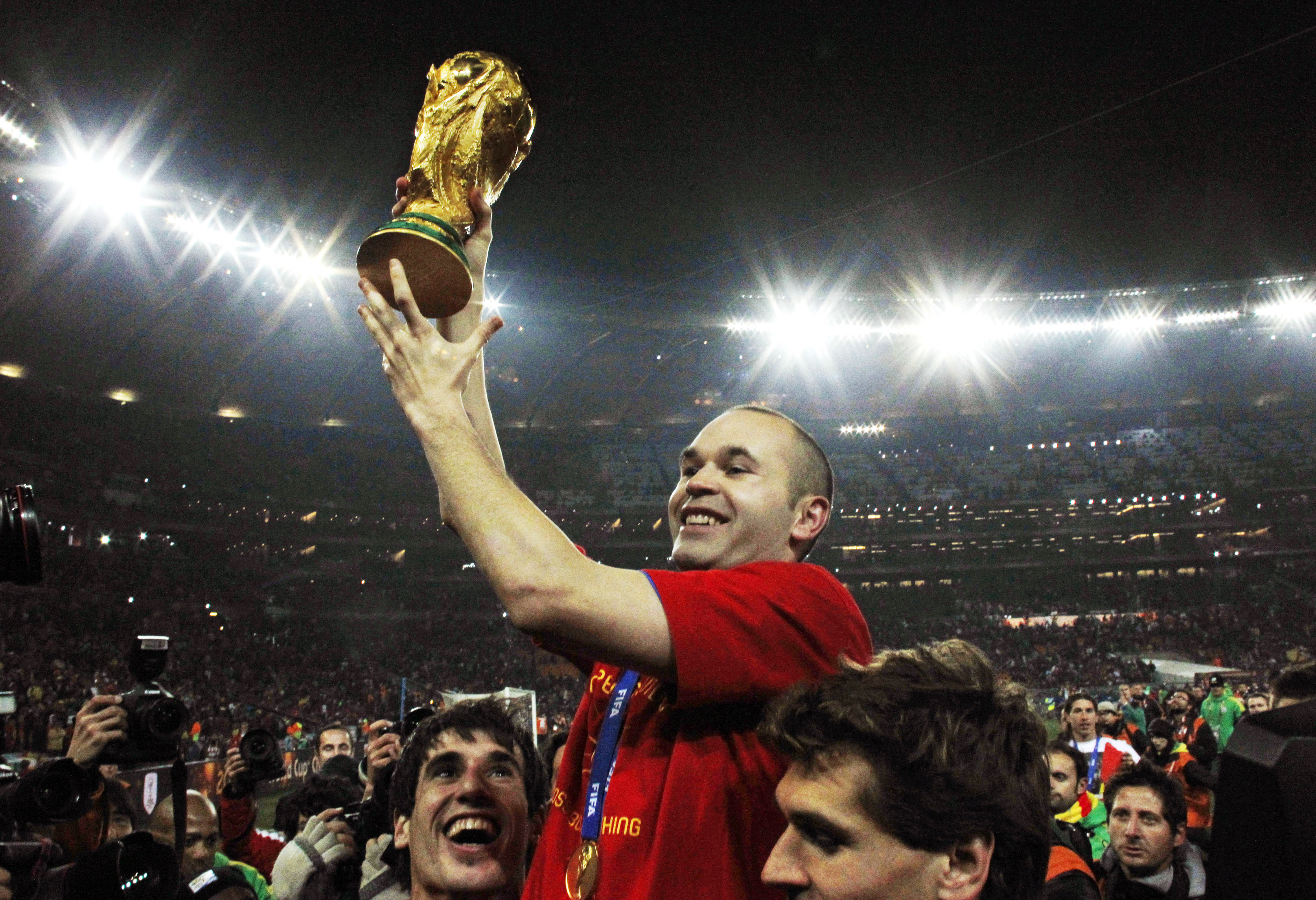 FILE - Spain's Andres Iniesta holds up the World Cup trophy after the World Cup final soccer match between the Netherlands and Spain at Soccer City in Johannesburg, South Africa, July 11, 2010. Andres Iniesta who scored Spain's World Cup-winning goal in 2010 and was one of the key players who made Barcelona's tiki-taka thrive for so long, announced his retirement from soccer on Tuesday.