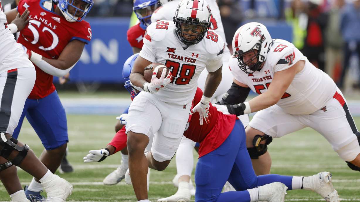 FILE - Texas Tech running back Tahj Brooks (28) rushes for a first down during the first half of an NCAA college football game against Kansas, Nov. 11, 2023, in Lawrence, Kan.