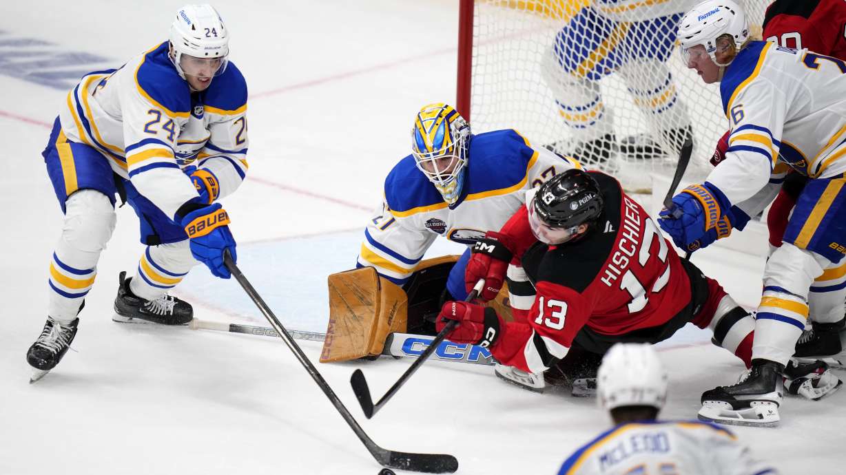 Buffalo Sabres' Dylan Cozen, left, challenges New Jersey Devils' Nico Hischier, 2nd right, during the NHL hockey game between Buffalo Sabres and New Jersey Devils, in Prague, Czech Republic, Saturday, Oct. 5, 2024.