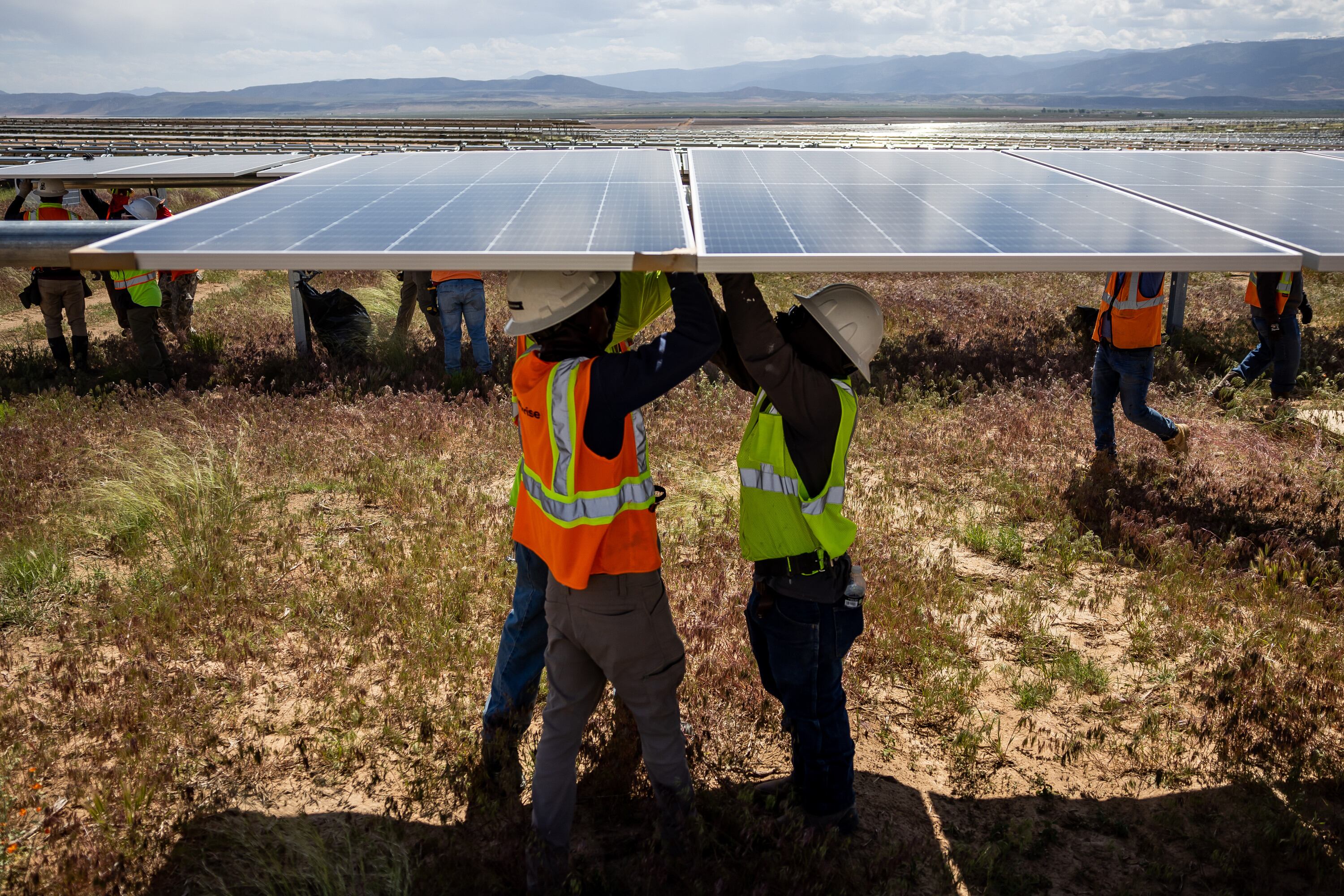 Crews work to install photovoltaic panels on racking at the Appaloosa Solar 1 project near Cedar City on June 8, 2023.