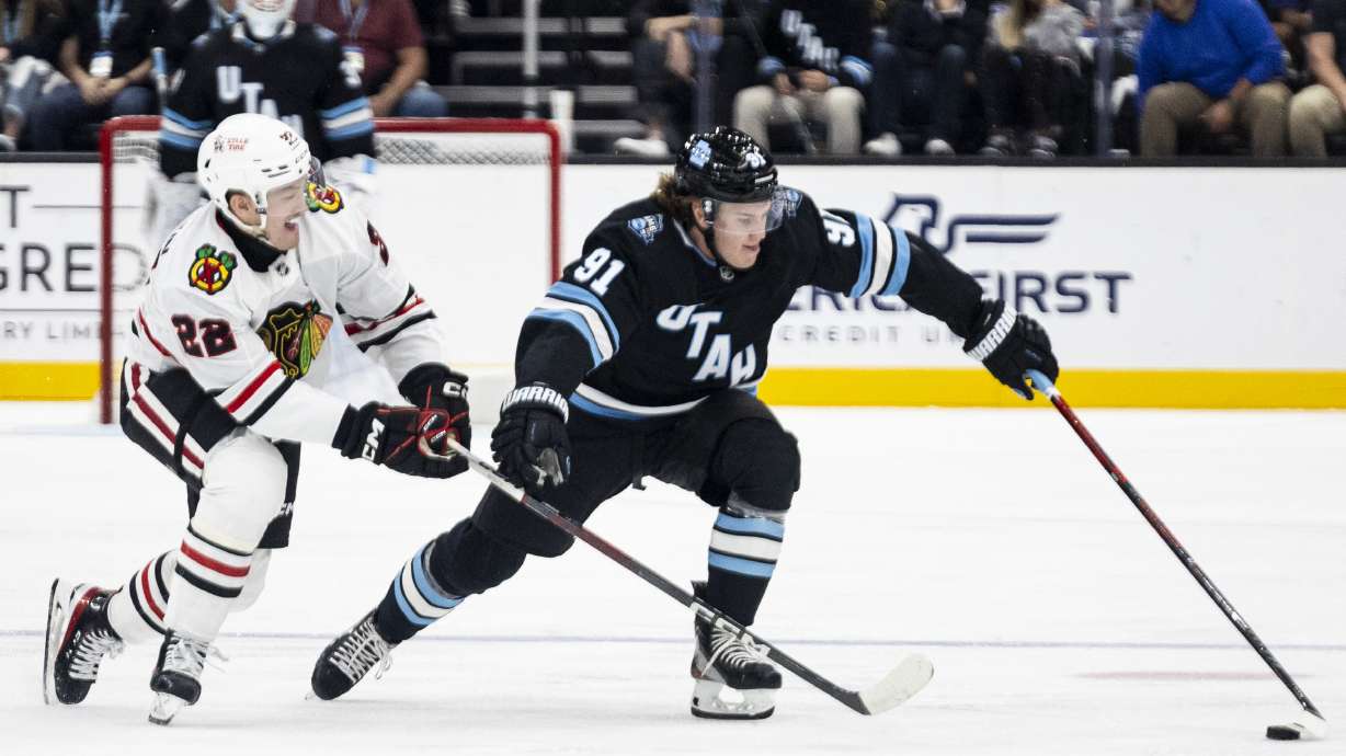 Utah Hockey Club right wing Josh Doan (91) and Chicago Blackhawks right wing Joey Anderson (22) compete for possession of the puck during a game held at the Delta Center in Salt Lake City on Tuesday, Oct. 8, 2024.