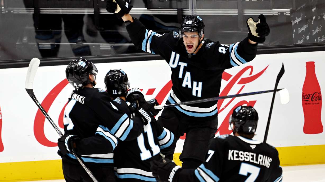 Utah Hockey Club center Jack McBain (22) joins teammates Utah Hockey Club defenseman Juuso Valimaki (4) Utah Hockey Club right wing Dylan Guenther (11) and Utah Hockey Club defenseman Michael Kesselring (7) after Utah Hockey Club’s first goal in their inaugural game and season opener against the Chicago Blackhawks at the Delta Center in Salt Lake City, on Tuesday Oct. 8, 2024.
