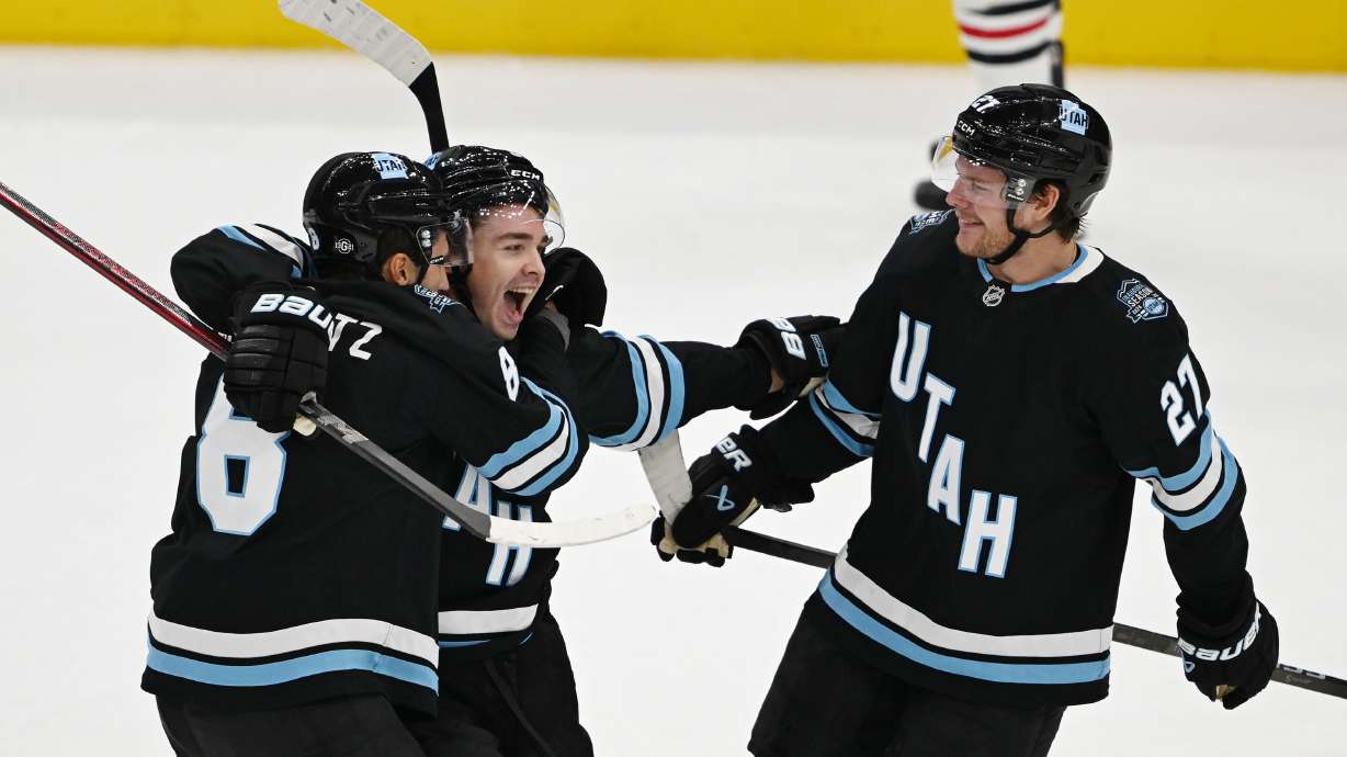Utah Hockey Club center Clayton Keller (9) celebrates a goal with teammates Utah Hockey Club center Nick Schmaltz (8) and Utah Hockey Club center Barrett Hayton (27) as they play in their inaugural game and season opener against the Chicago Blackhawks at Delta Center in Salt Lake City, on Tuesday Oct. 8, 2024. Utah won 5-2.
