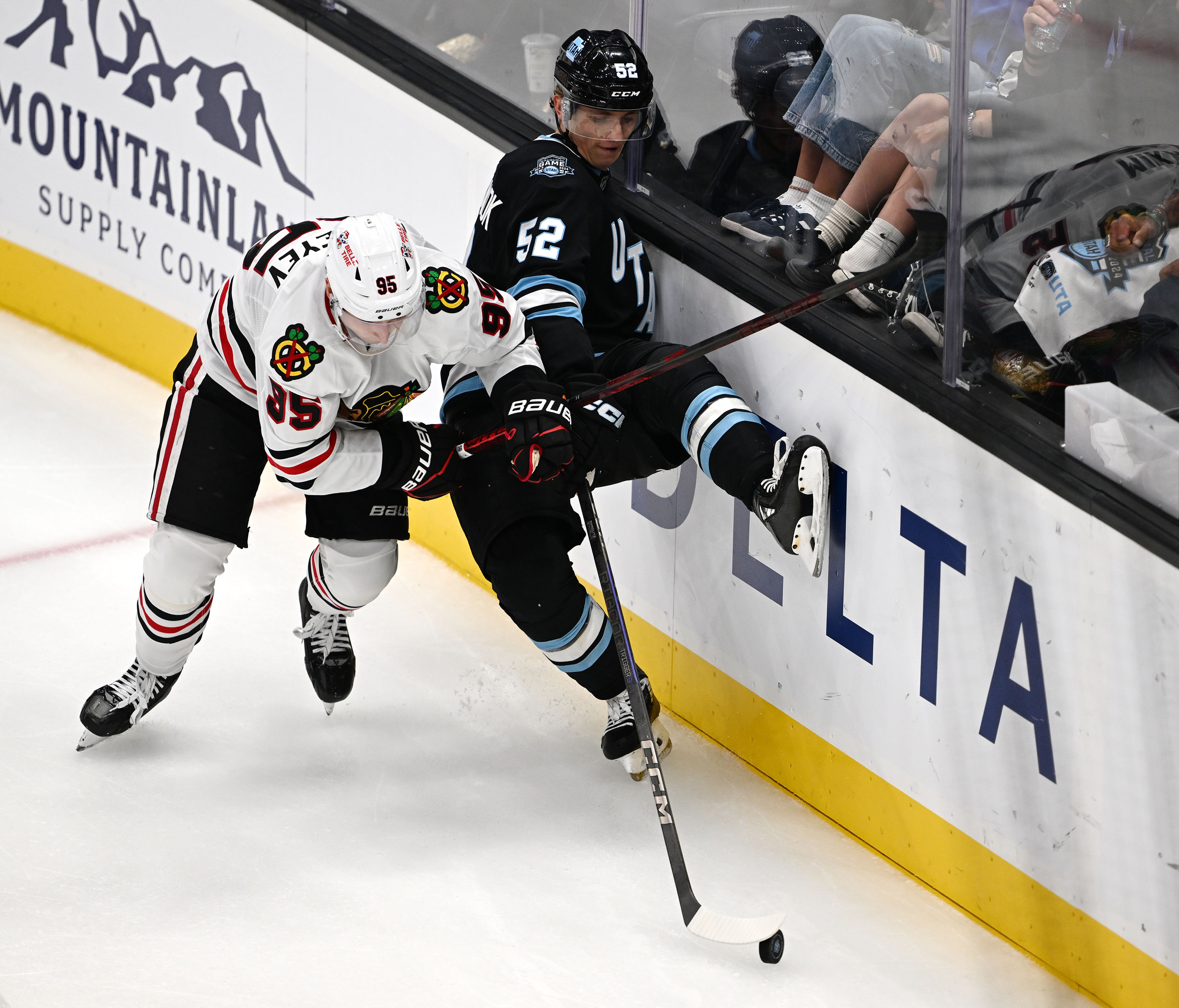 Chicago Blackhawks right wing Ilya Mikheyev (95) checks Utah Hockey Club defenseman Vladislav Kolyachonok (52) into the wall as they play in the inaugural and season opener at Delta Center in Salt Lake City, on Tuesday Oct. 8, 2024.