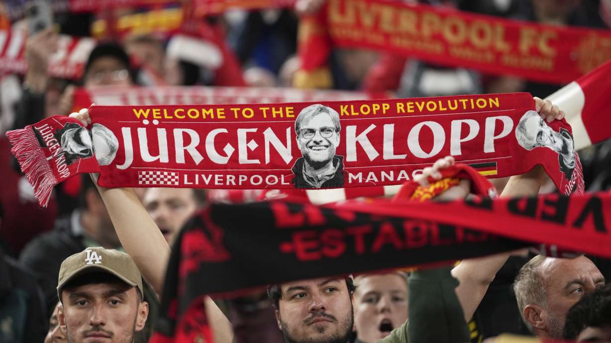 A Liverpool fan holds up a scarf with a picture of former team coach Juergen Klopp, during the English League Cup soccer match between Liverpool and West Ham United at Anfield Stadium, Liverpool, England, Wednesday, Sept. 25, 2024.