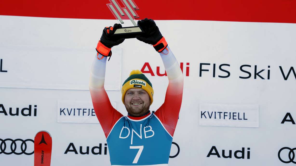 FILE - Switzerland's Niels Hintermann celebrates on the podium after winning an alpine ski, men's World Cup downhill race, in Kvitfjell, Norway, Saturday, Feb. 17, 2024.